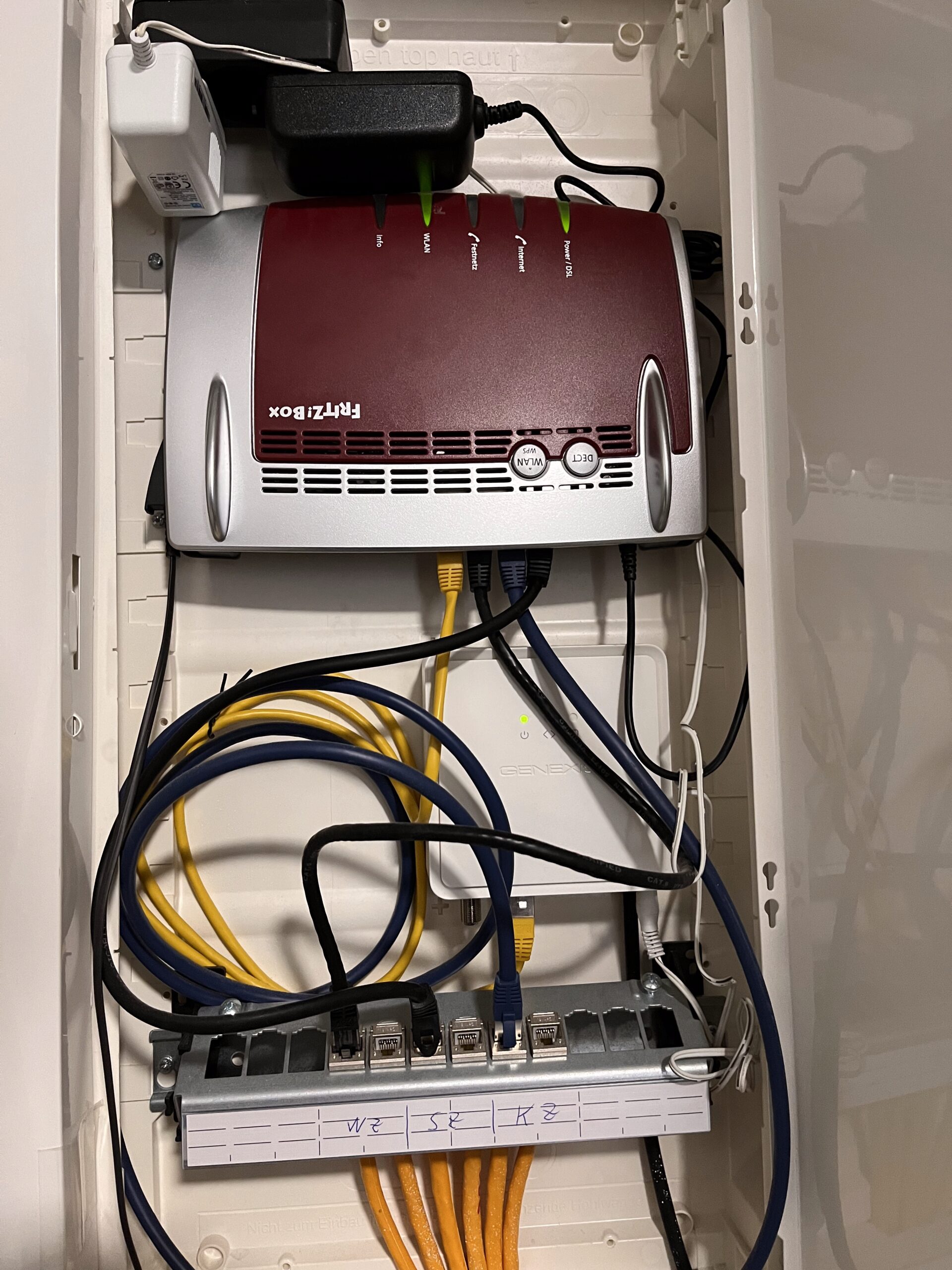 FRITZ!Box Router mit Glasfaser ONT und Patchpanel im Multimedia Verteiler zur Netzwerk- und WLAN-Versorgung in einem Wohngebäude in Düsseldorf
